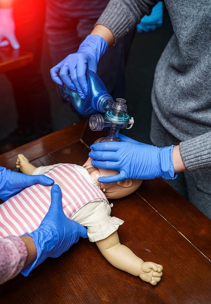 Foto procedimento médico de treinamento de rcp. demonstração da compressão da mama em uma boneca de rcp na aula.