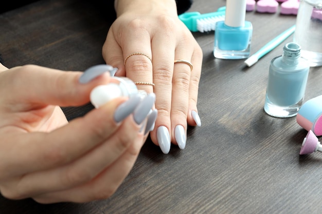 Procedimento para cuidar das unhas na mesa de madeira, close-up