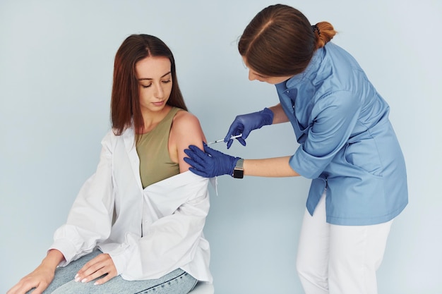 Procedimento simples, mas eficaz Médico de uniforme fazendo vacinação ao paciente