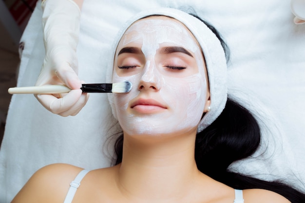 Procedimiento cosmético facial en el salón de spa el procedimiento para aplicar una máscara en la cara de una hermosa ...