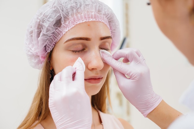 Procedimiento cosmético para rellenar el surco nasolagrimal y mesoterapia alrededor de los ojos para una hermosa joven. Cosmetología moderna.