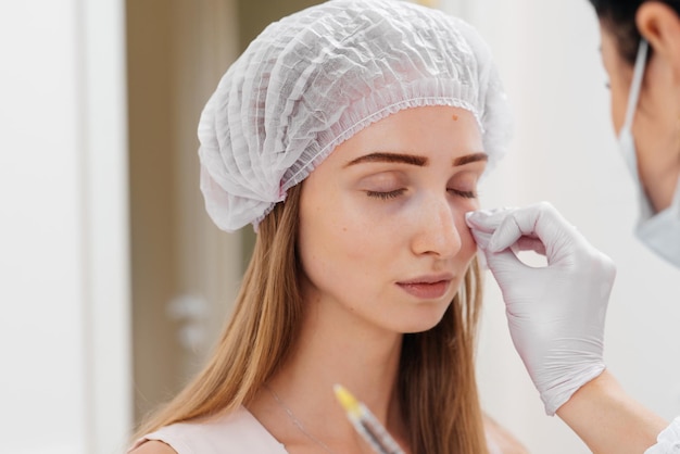 Procedimiento cosmético para rellenar el surco nasolagrimal y mesoterapia alrededor de los ojos para una joven hermosa Cosmetología moderna