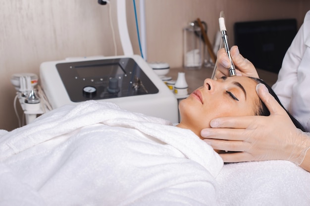 Foto procedimiento de cosmetología y belleza en el salón de spa tratamiento facial de la piel mujer esperando durante la pr ...