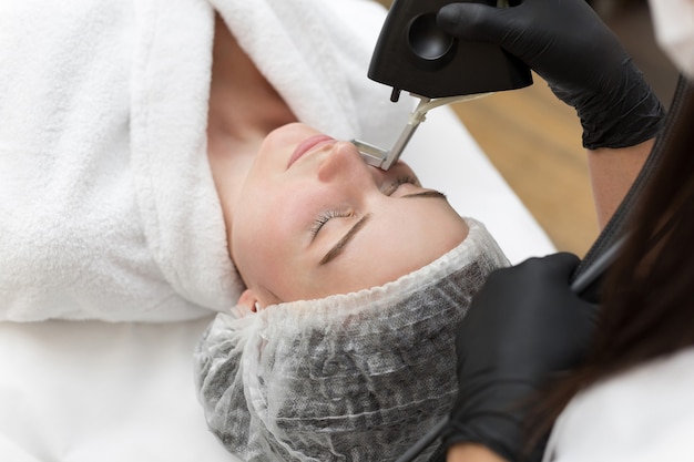 Procedimiento de cosmetología de depilación de un terapeuta en la clínica de spa de belleza cosmética. Depilación láser y cosmetología