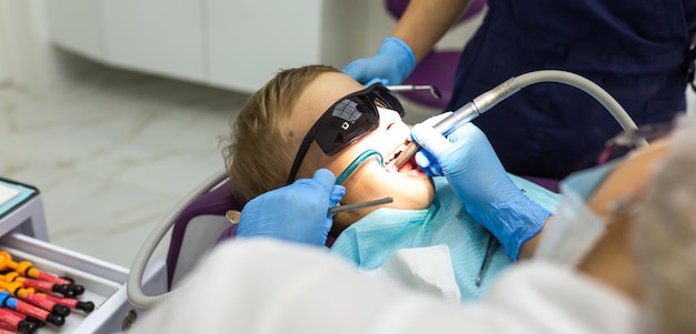 Procedimiento de dentista de primer plano de los dientes de los niños Un niño con un dentista en un consultorio dental