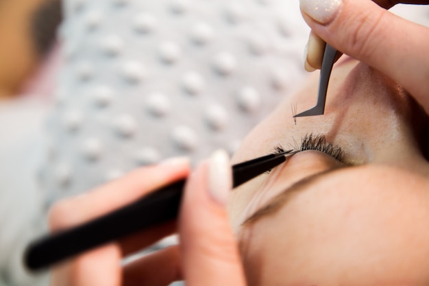 Procedimiento de extensión de pestañas. Ojo de mujer con pestañas largas. Las pestañas, de cerca, macro, enfoque selectivo.