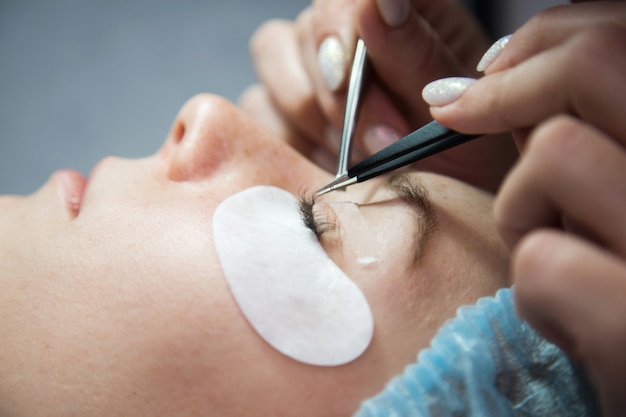 Procedimiento de extensión de pestañas. Ojo de mujer con pestañas largas. Las pestañas, de cerca, macro, enfoque selectivo.