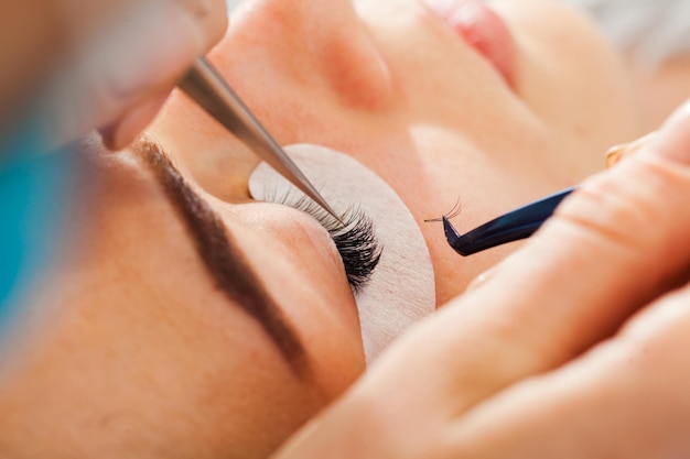 Procedimiento de extensión de pestañas. Ojo de mujer con pestañas largas. Pestañas de cerca, vista macro y enfoque selectivo.