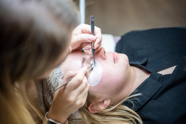 Procedimiento de extensión de pestañas en salón de belleza pestañas primer plano concepto spa lash