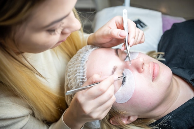 Procedimiento de extensión de pestañas en salón de belleza pestañas primer plano concepto spa lash