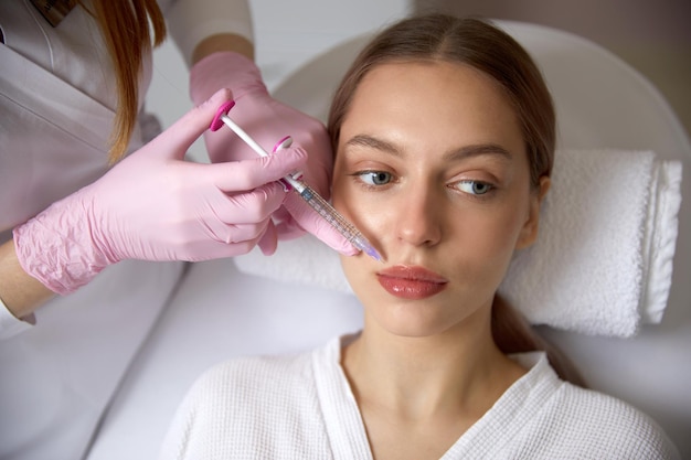 Procedimiento de inyecciones faciales rejuvenecedoras para apretar y suavizar las arrugas en la piel facial de un