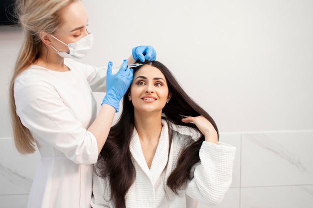 Procedimiento de mesoterapia capilar en la clínica de cosmetología El médico cosmetólogo hace una inyección de botulino