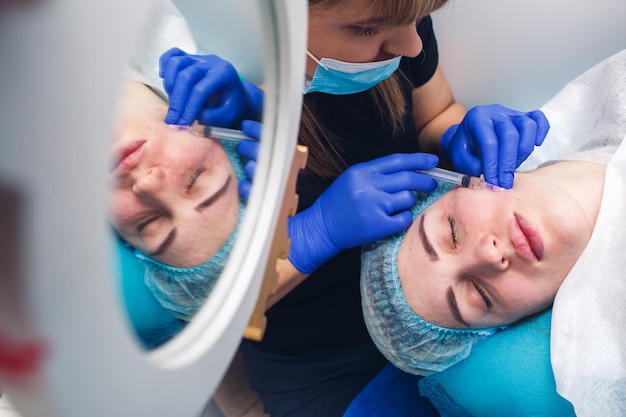 Procedimiento de mesoterapia real en la cara de niña Inyecciones de piel para rejuvenecimiento