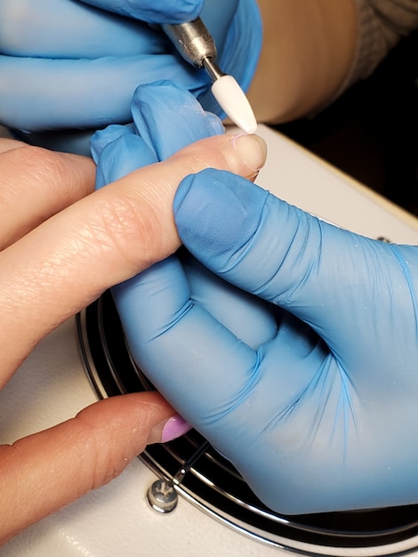 Procesamiento de uñas con manicura de hardware en un salón de belleza.