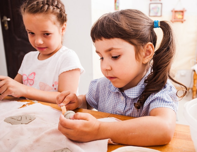 Procesar figuras de modelado de plastilina. Los niños están sentados en la mesa.