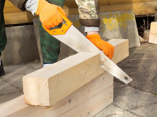 El proceso de aserrado manual de madera un hombre aserrando una madera al construir una casa