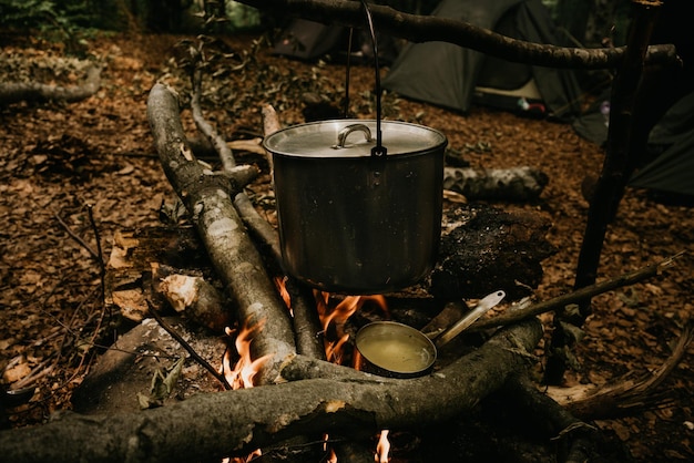 Proceso de cocción en la fogata en el campamento en el bosque