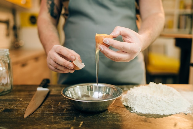 Proceso de cocción de pasta, manos de chef masculino con huevo