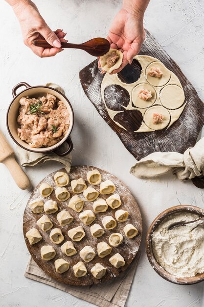 El proceso de cocinar albóndigas: las manos de las mujeres esculpen albóndigas.