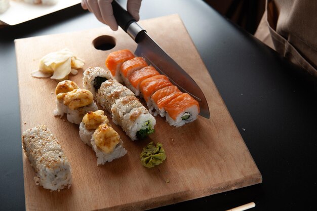 El proceso de cocinar sushi en un restaurante Sushi en una tabla de madera sobre un fondo negro