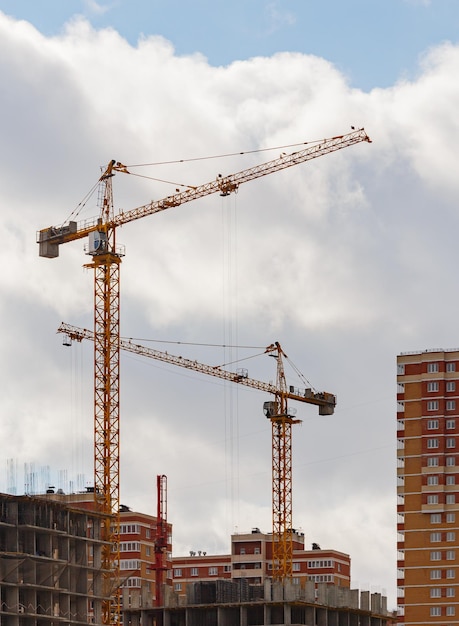 Proceso de construcción de un gran edificio de apartamentos residenciales con grúa sobre fondo de cielo nublado