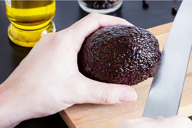 Proceso de corte de aguacate Haas sobre tabla de cortar.