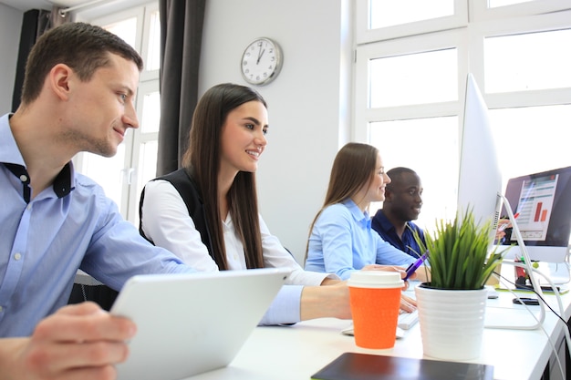 Proceso de coworking, proyecto de trabajo en equipo de diseñadores. Foto equipo de jóvenes empresarios trabajando con una nueva oficina moderna de inicio