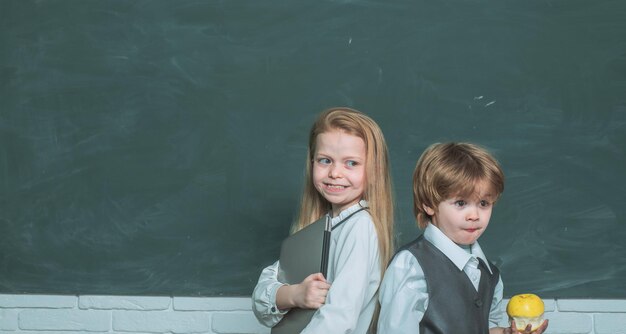 Proceso educativo educación septiembre maestra colegiala ayudando a colegial con pizarra de lección ...