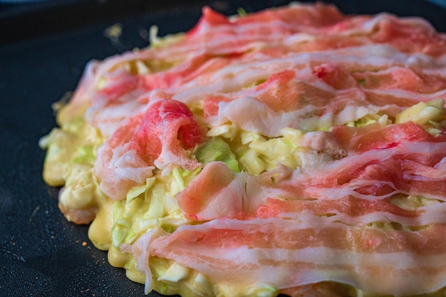 Foto el proceso de elaboración del okonomiyaki japonés