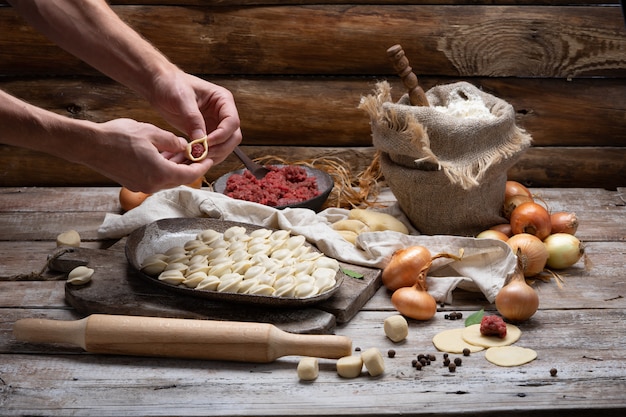 Proceso de elaboración de pelmeni, ravioles o albóndigas con carne.