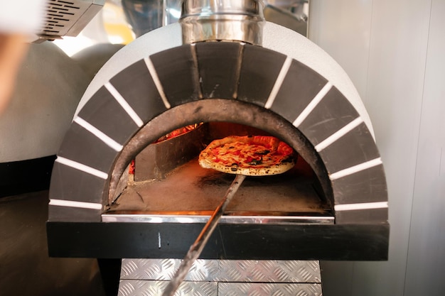 El proceso de elaboración de la pizza Pizza italiana en horno de leña La pizza italiana se cocina en horno de leña