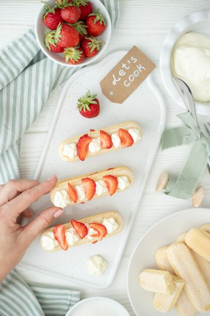 El proceso de elaboración de un postre de galletas saboyanas fresas y buttercream