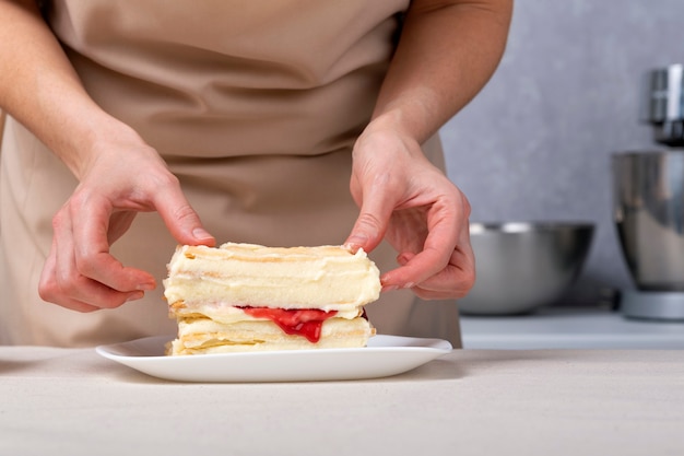 Proceso de elaboración de tarta con relleno de vainilla y frutas. El chef de repostería está preparando la torta.