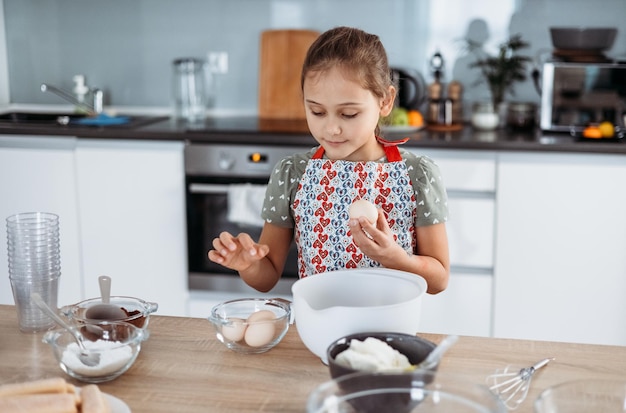 Proceso de elaboración del tiramisú en la cocina niña haciendo postre italiano con cacao y melindres bañados en espresso con crema de mascarpone paso a paso 2