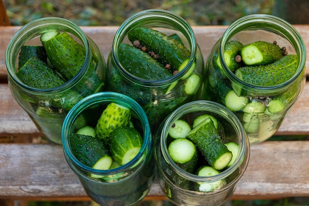 El proceso de enlatado de pepinillos en escabeche, pepinos encurtidos en frascos de vidrio.