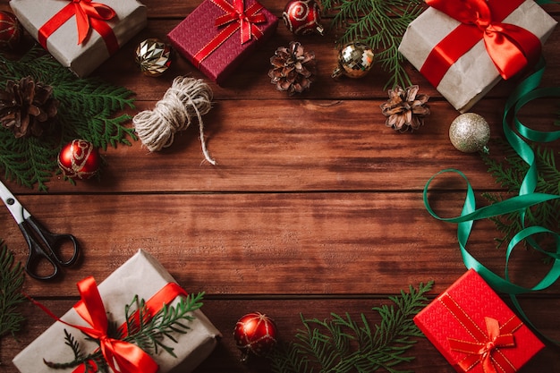 Proceso de envoltura de regalos de Navidad. Mujer decora caja con una cinta roja.