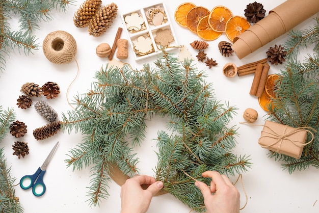 proceso de hacer una corona de árbol de Navidad en casa con ramas de abeto