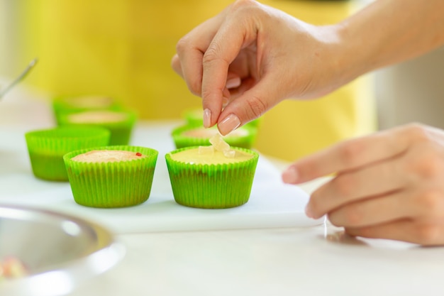 El proceso de hacer cupcakes. Creación de pasteles por pasteleros profesionales.