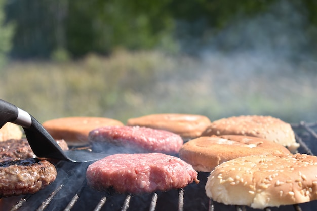 El proceso de hacer hamburguesas a la parrilla en el jardín.