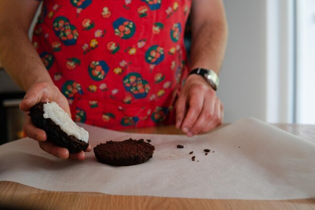 Foto el proceso de hacer pastel de chocolate por un hombre en la cocina.