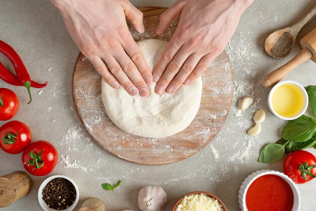 El proceso de hacer pizza margarita Manos masculinas vista superior Pasta de tomate con queso