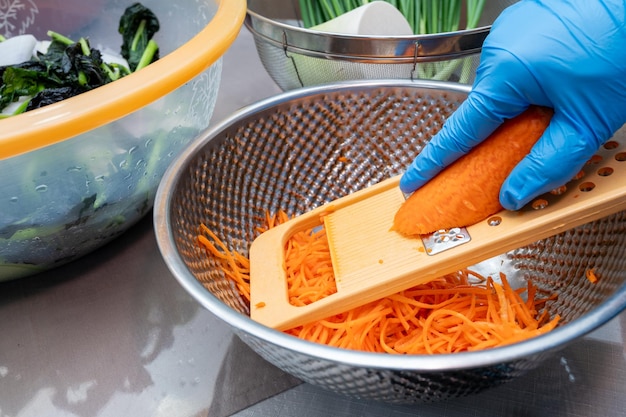 Foto el proceso de hacer un plato tradicional coreano kimchi una mujer con guantes está preparando varios ingredientes necesarios para el kimchi