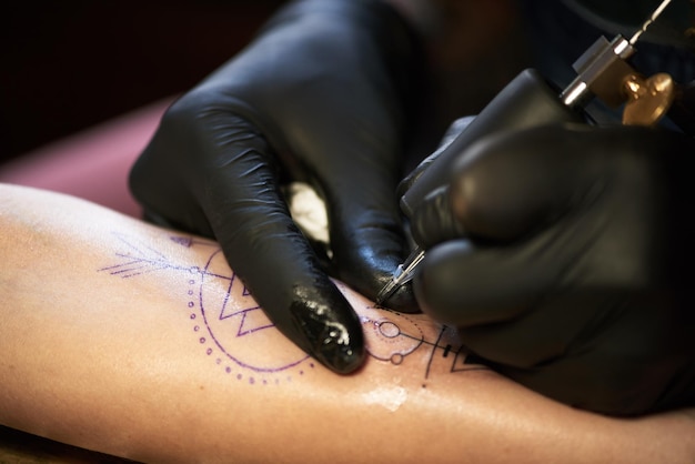 Proceso de hacer un tatuaje en la mano.