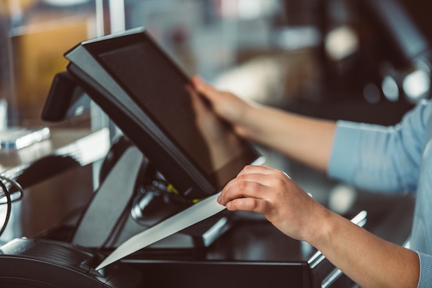 Foto proceso de impresión de factura para un cliente, procesador de tarjetas de crédito, impresora de recibos con factura de compra en papel y monitor de pantalla táctil, pos