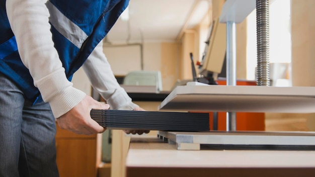 Foto proceso de impresión en la máquina de imprenta: el trabajador inserta hojas de papel, vista cercana