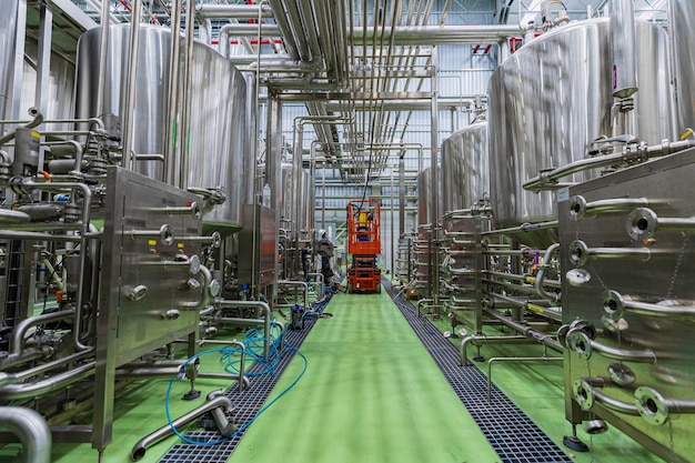 Proceso de inspección visual del proyecto de trabajo masculino en tanques de acero inoxidable y en instalaciones de tanques de equipos para cervezas y bebidas en la bodega con inoxidable vertical