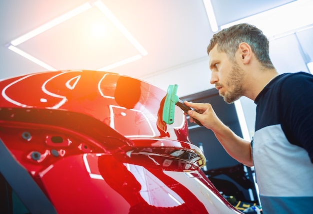 El proceso de instalación de la película protectora en el nuevo coche rojo