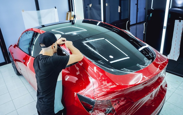 El proceso de instalación de la película protectora en el nuevo coche rojo