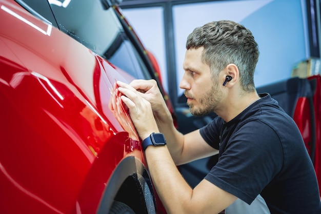 El proceso de instalación de la película protectora en el nuevo coche rojo