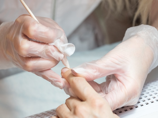 Proceso de manicura. Limpiar la uña del polvo, cerrar